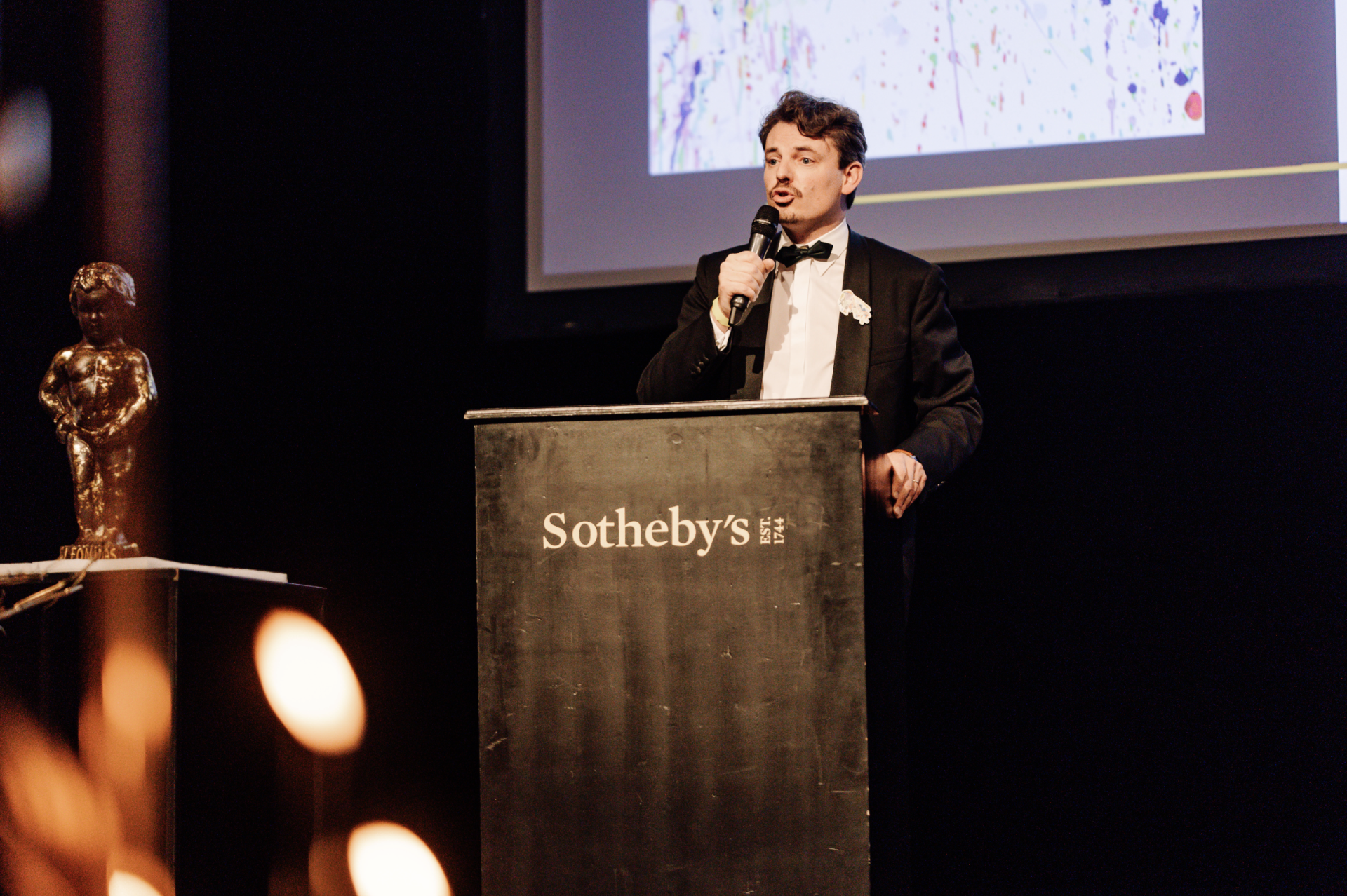 Emmanuel van De Putte van Sotheby's auction geeft een inleidende toespraak voor de veiling van de avond. 